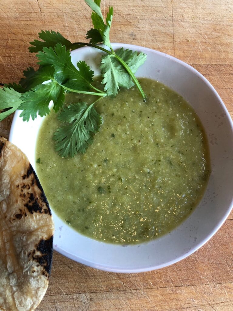 Tomatillo salsa in a small bowl and garnished with cilantro.