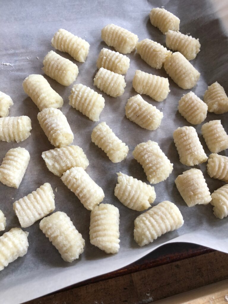 Homemade potato gnocchi on a tray.