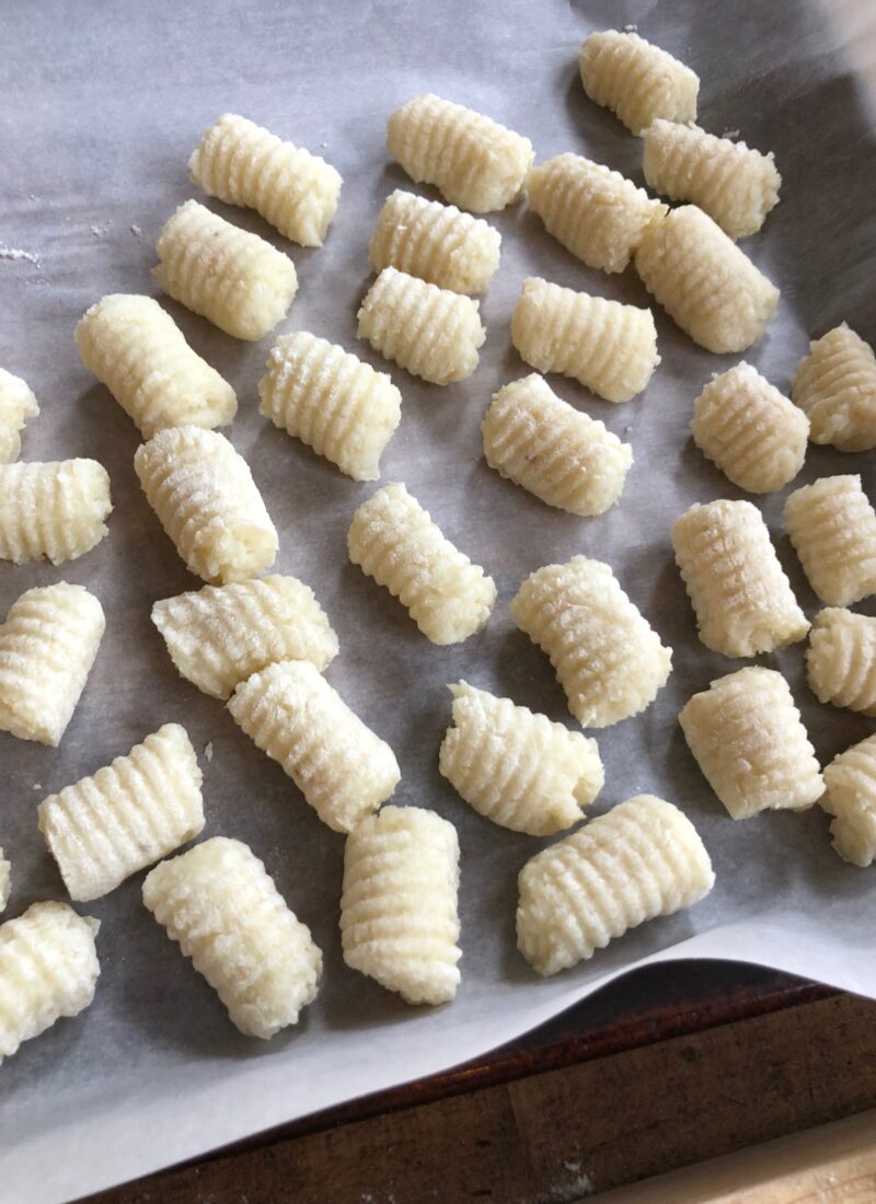 Homemade potato gnocchi on a tray.