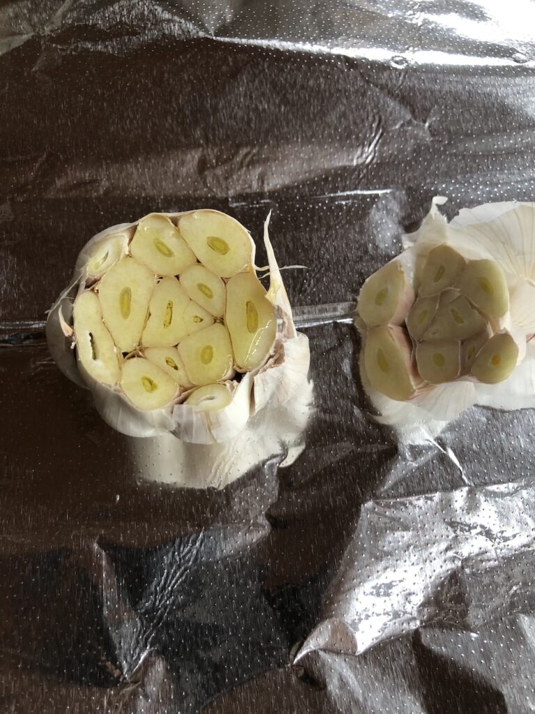 Placing the garlic in aluminum foil to roast in the oven.