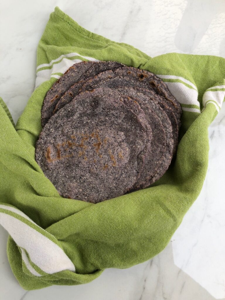 Homemade blue corn tortillas in a basket.