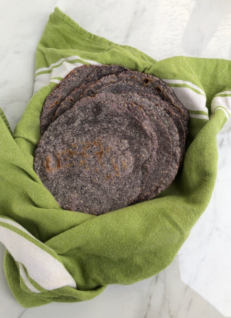 Homemade blue corn tortillas in a basket.