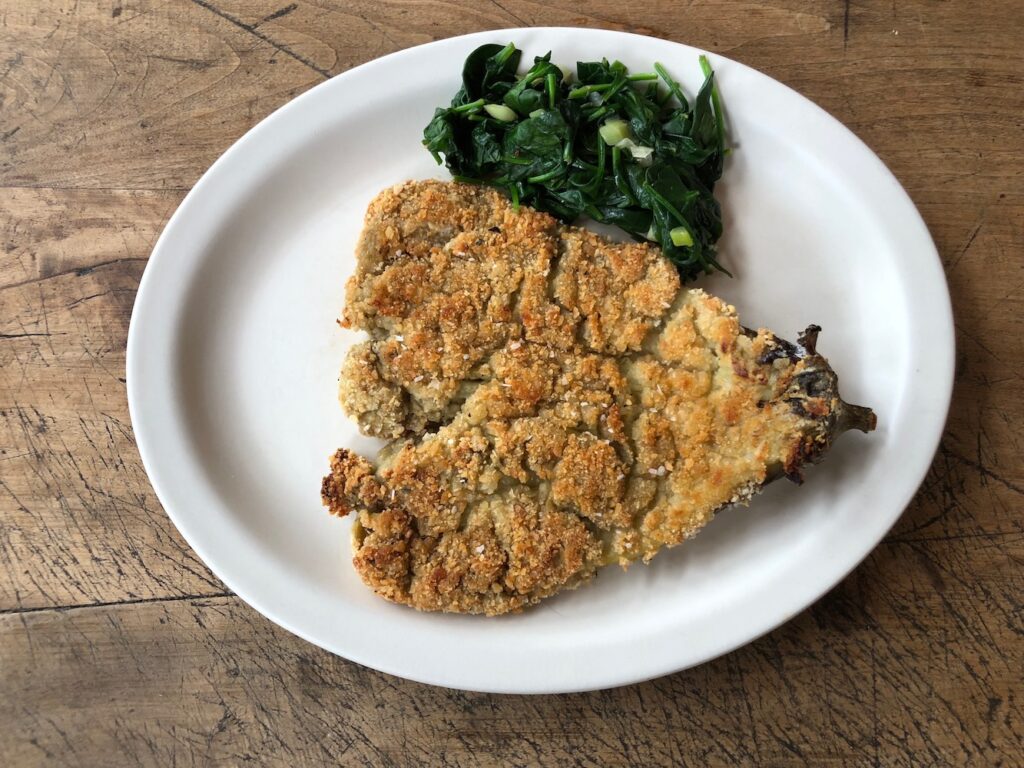 Breaded eggplant served on a dinner plate.