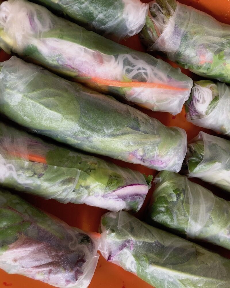 Spring rolls made with rice paper being served on a platter.